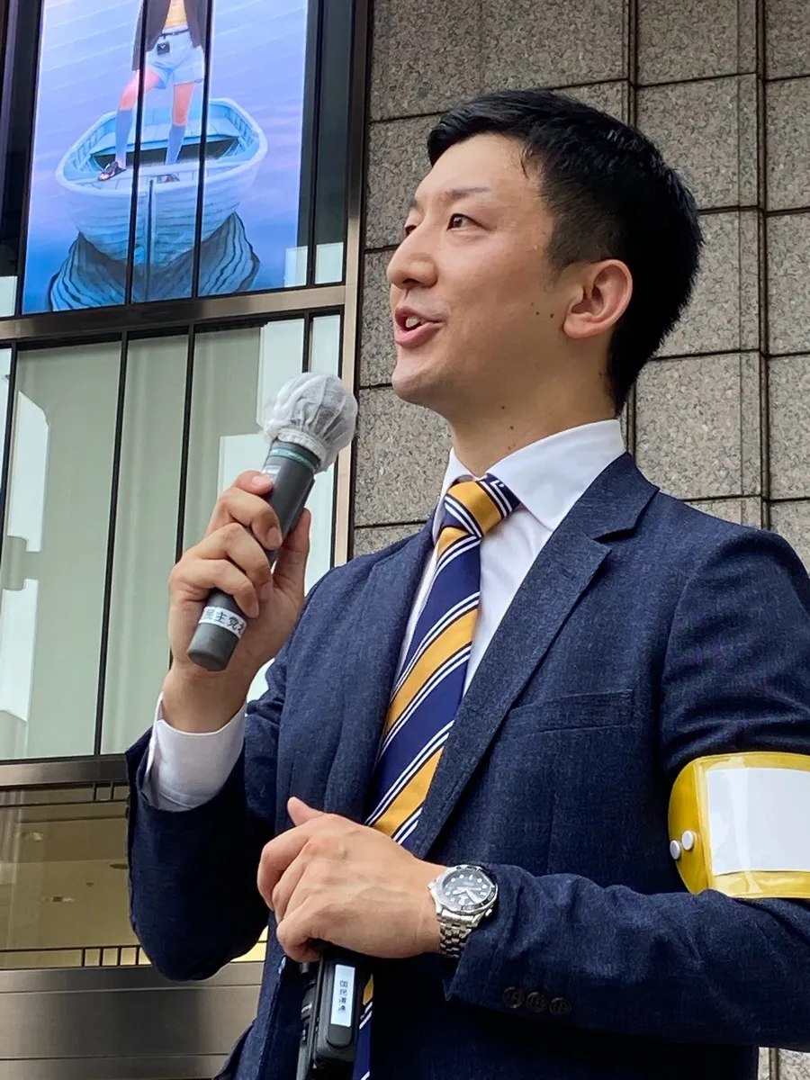 マイクを持って街頭で語りかける阿部恭介