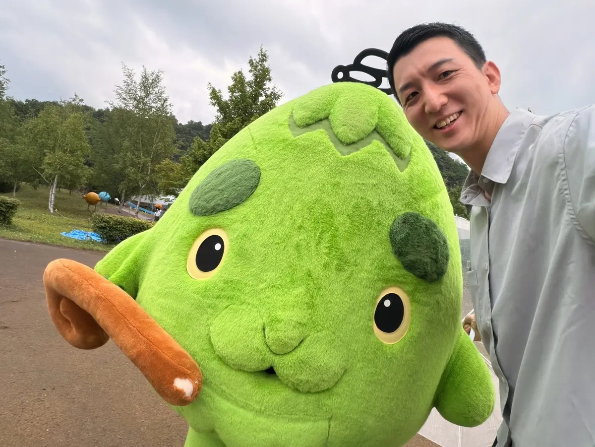 地域の行事でマスコットと並んで写る阿部恭介
