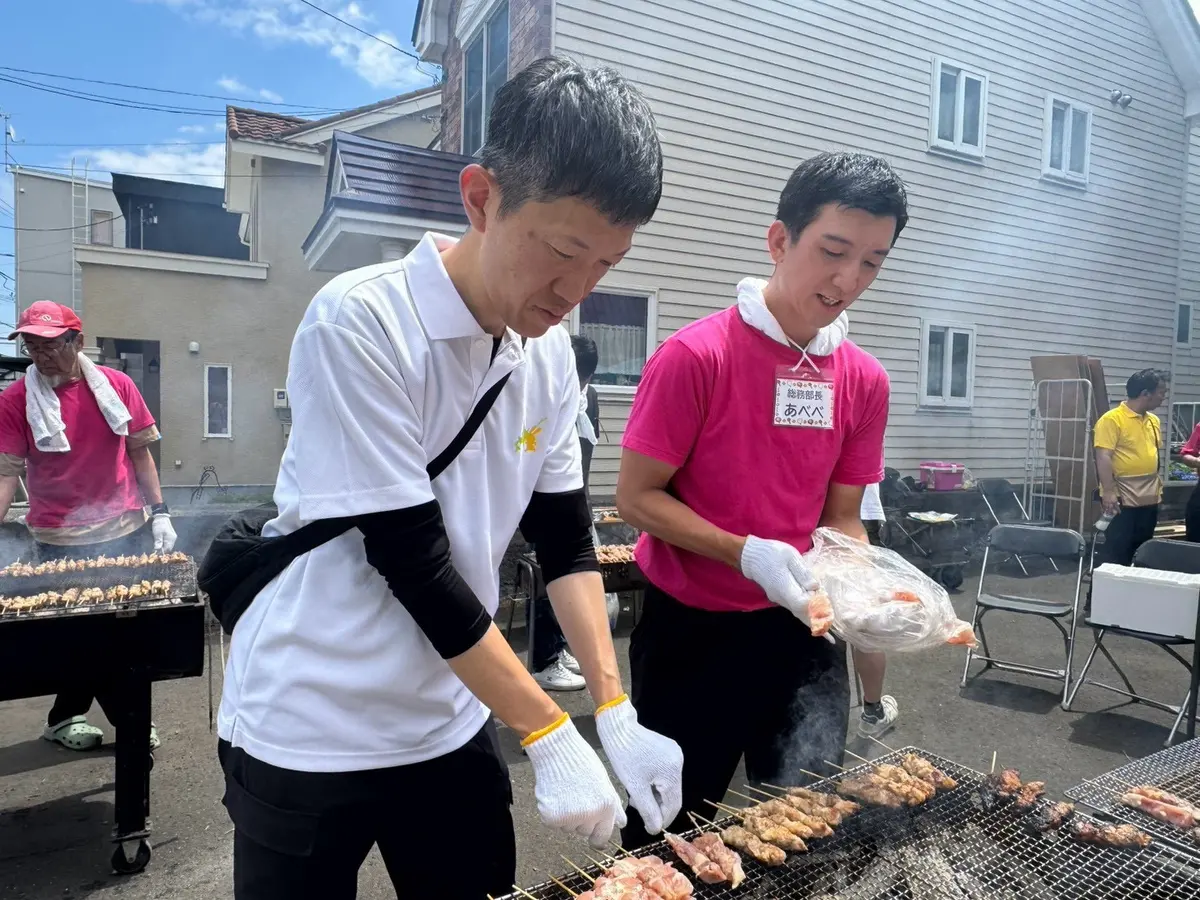 夏まつりの焼き台で仲間と調理する阿部恭介